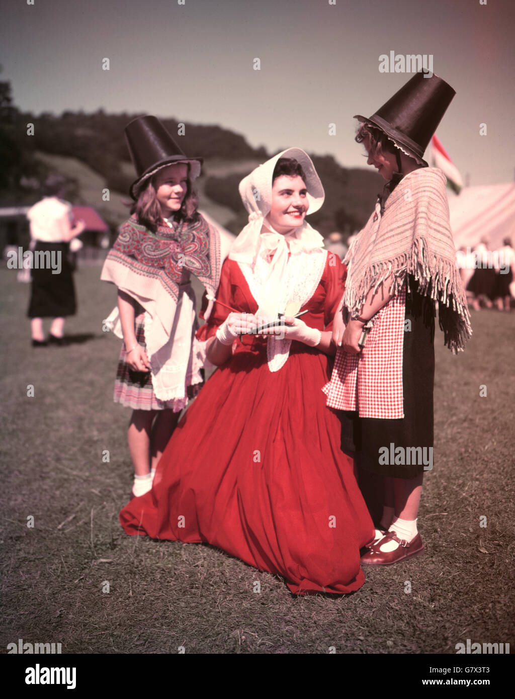 Kitty Strydom, 25 ans, de Bloemfontein, Afrique du Sud, signe son autographe pour Julie Saunders (l), âgée de 10 ans, et Helen Williams, âgée de 9 ans, deux filles galloises en costume national. Mlle Strydom est à l'International musical Eisteddfod de Llangollen, au nord du pays de Galles, où elle chante avec les Volkspelers, un groupe de danse et de chant tiré de toutes les parties de l'Afrique du Sud. Banque D'Images