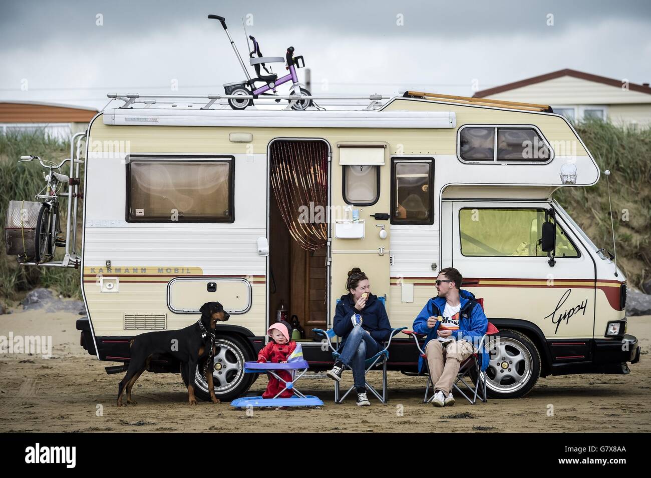 Les gens pique-niquent à côté de leur campervan sur la plage de Brean dans le Somerset. Banque D'Images