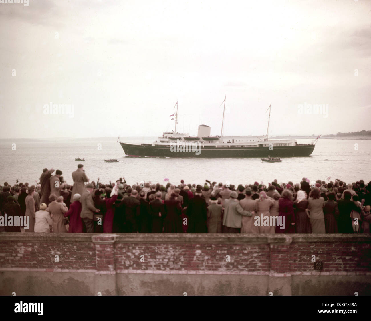 Une foule de adeptes sur la côte se déferle vers le nouveau yacht royal Britannia comme - avec le prince Charles et la princesse Anne à bord - elle navigue de Portsmouth au début de son voyage en Méditerranée. Les enfants royaux doivent rencontrer leurs parents, la Reine et le duc d'Édimbourg, à Tobruk, en Libye. Banque D'Images