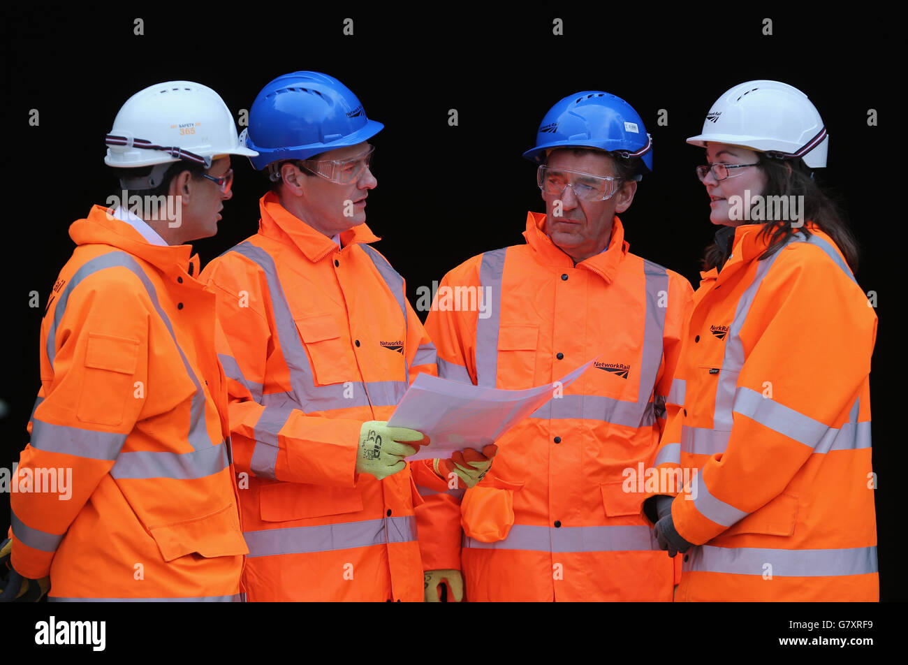 Le chancelier George Osborne (2e à gauche) et le secrétaire commercial Jim O'Neill (2e à droite) discutent avec les travailleurs lors d'une visite aux travaux d'électrification du tunnel de Farnworth à Bolton. Banque D'Images