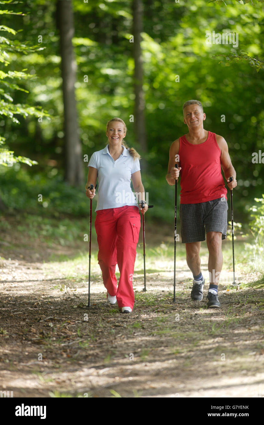 Femme, 42, et l'homme, 52, faire de la marche nordique Banque D'Images