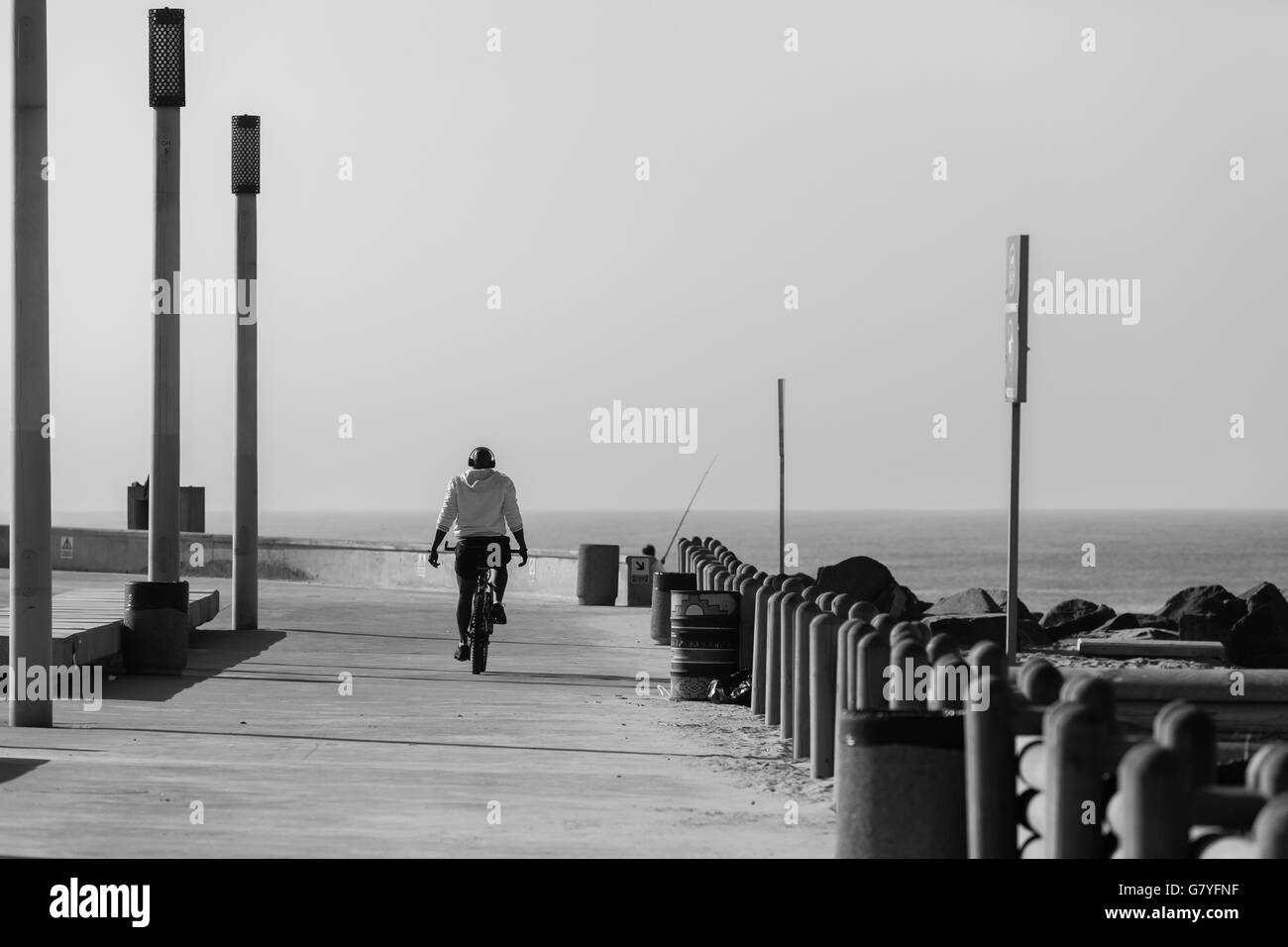 Casque vélo homme vélo musique promenade vers l'horizon de l'océan en noir et blanc. Banque D'Images