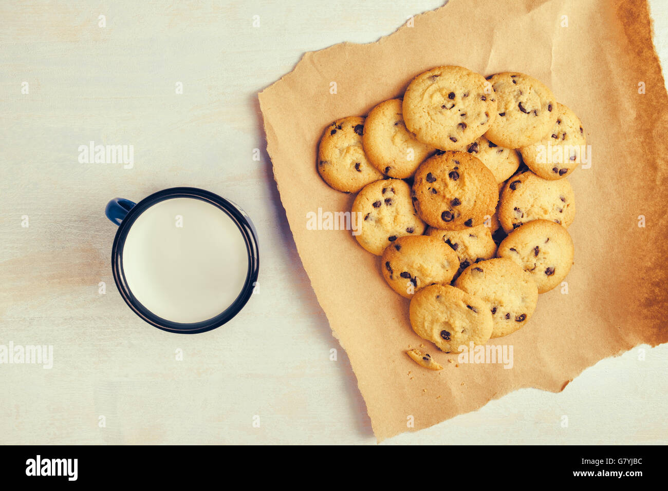 Des cookies aux pépites de chocolat et le lait tasse sur la table en bois rustique, vue du dessus Banque D'Images