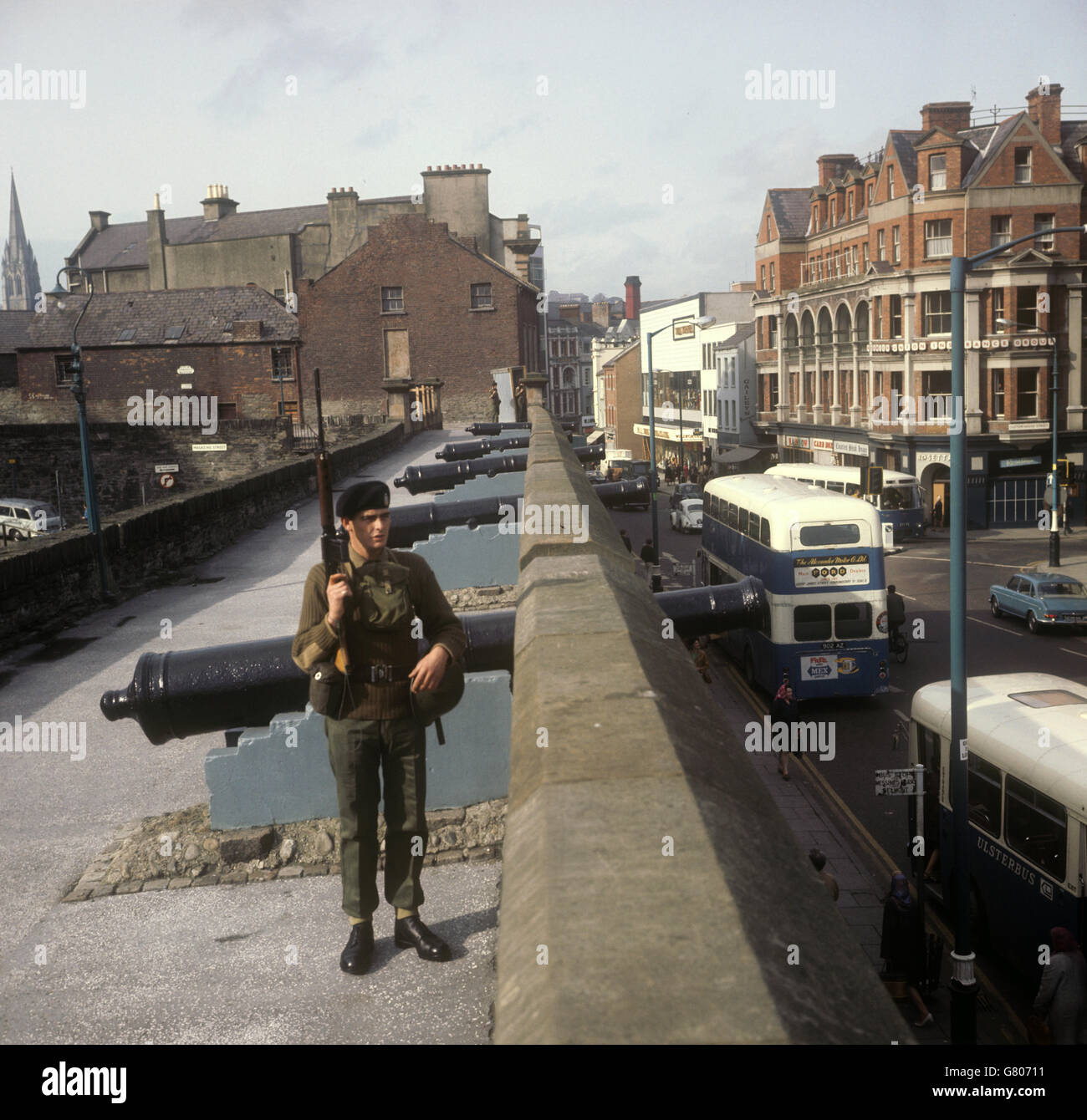 Le Soldat Davis Innes (1er Bataillon du Queen's Regiment), de Stirling, en Écosse, se dresse à côté de canons anciens sur les 'Derry Wallss', alors qu'il garde la ville troublée. Banque D'Images