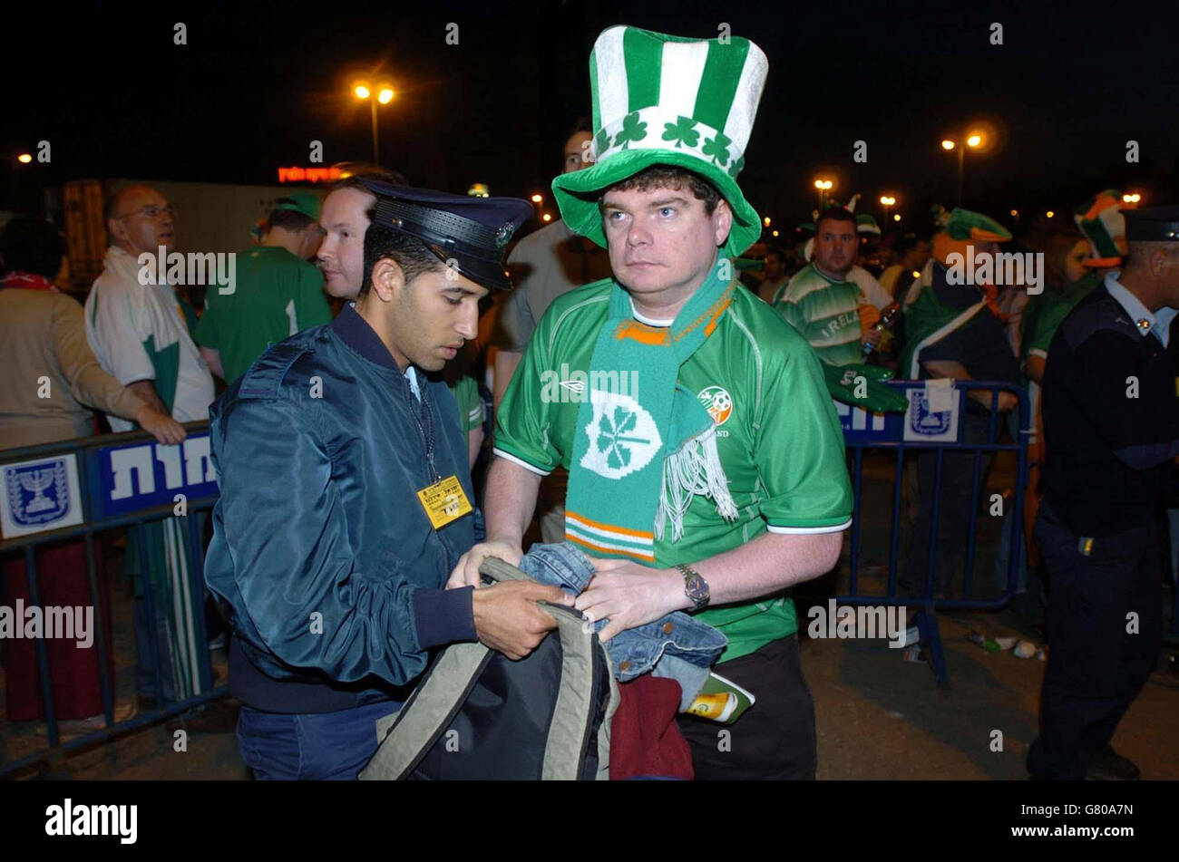 Un fan de football non identifié de la République d'Irlande est fouillé par un policier israélien avant d'entrer dans le stade. Banque D'Images
