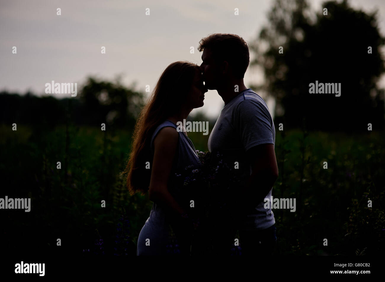 Couple aimant l'homme et la femme silhouettes noires contre le soleil lumineux date de la nature Banque D'Images
