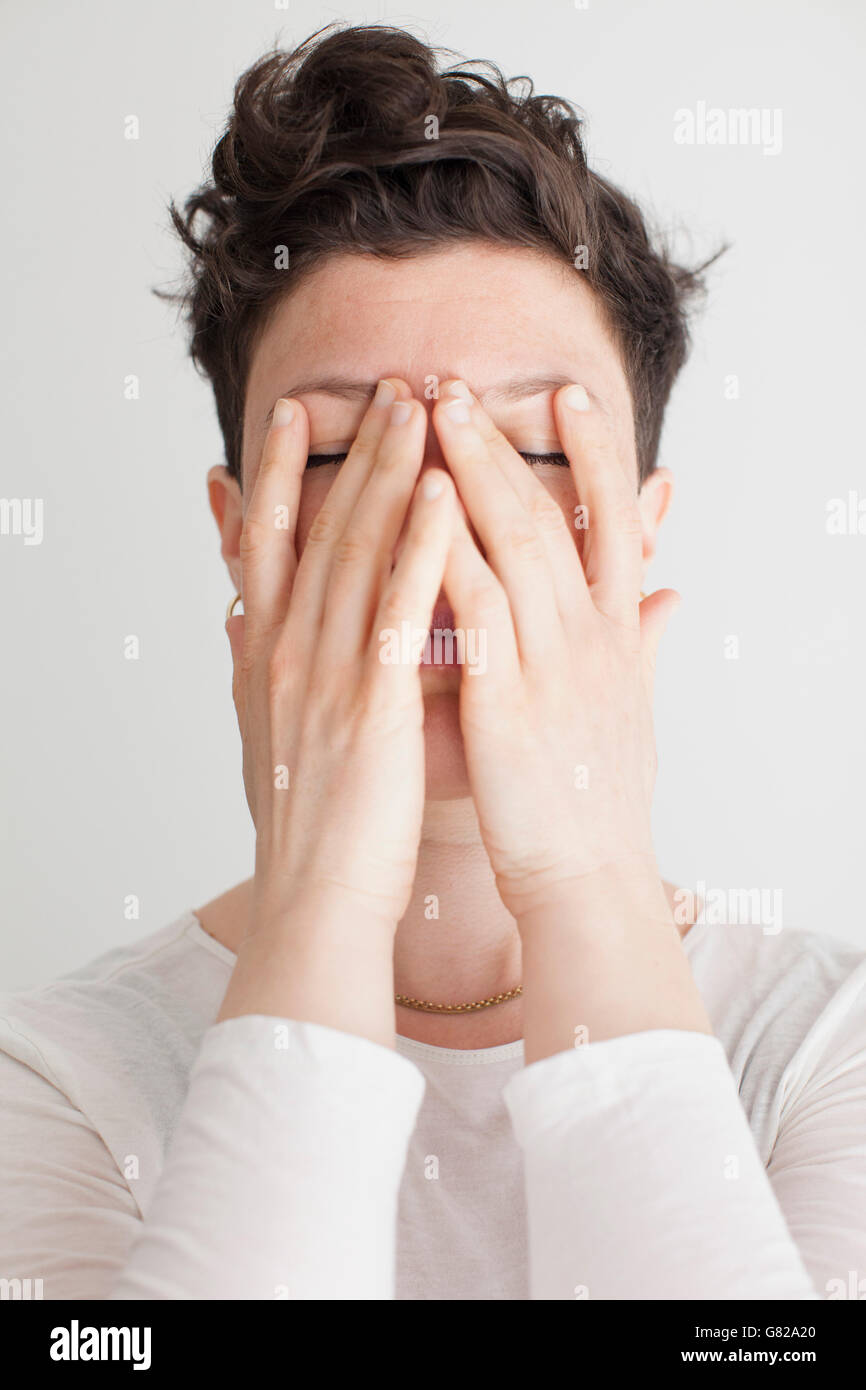 Close-up of mid adult woman covering her face with hands Banque D'Images