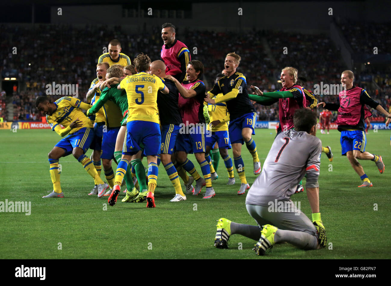 Football - UEFA European under-21 Championship - final - Suède / Portugal - Eden Stadium.Les joueurs suédois célèbrent la victoire de la fusillade de pénalité alors que le gardien de but portugais José sa (à droite) s'agenouille Banque D'Images