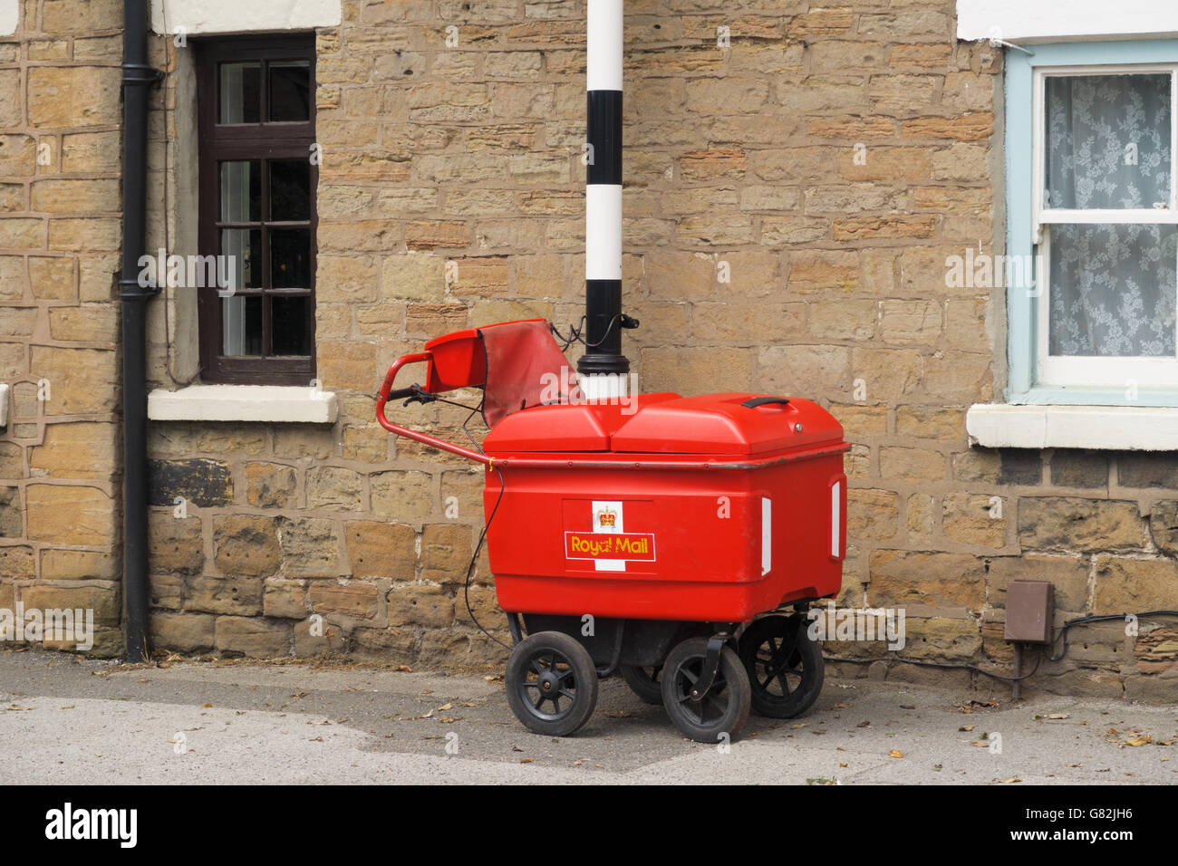 Un chariot de grande capacité de Royal Mail enchaîné à un poteau. Banque D'Images
