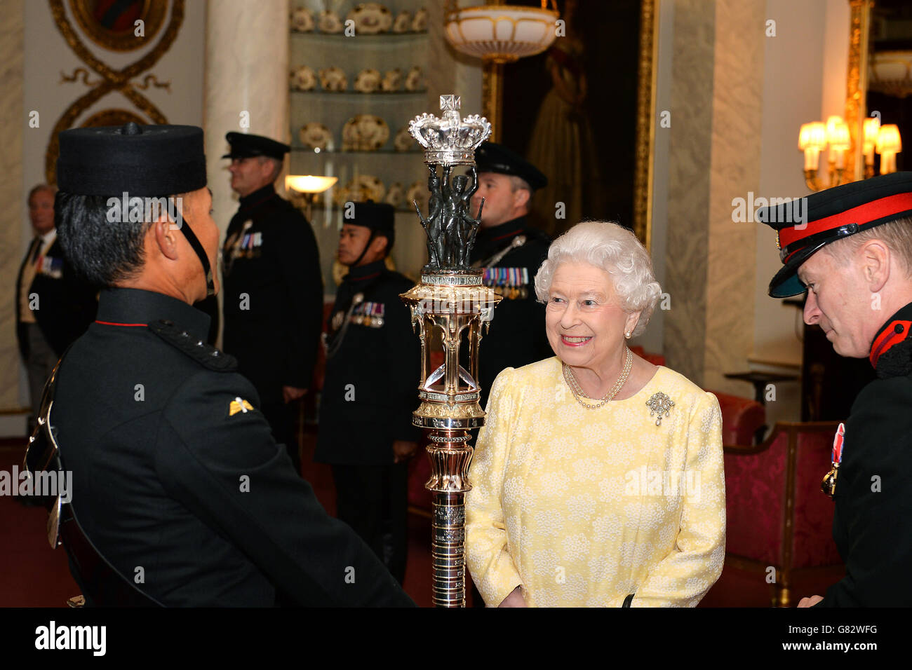 La reine Elizabeth II admire le truncheon Gurkha (personnel de cérémonie), qui est l'équivalent de Gurkha Rifles d'une couleur régimentaire (drapeau de bataille) et a été donné aux fusils par ordre de la reine Victoria en 1863, lors d'une observation du truncheon dans la salle Bow à Buckingham Palace à Londres. Banque D'Images