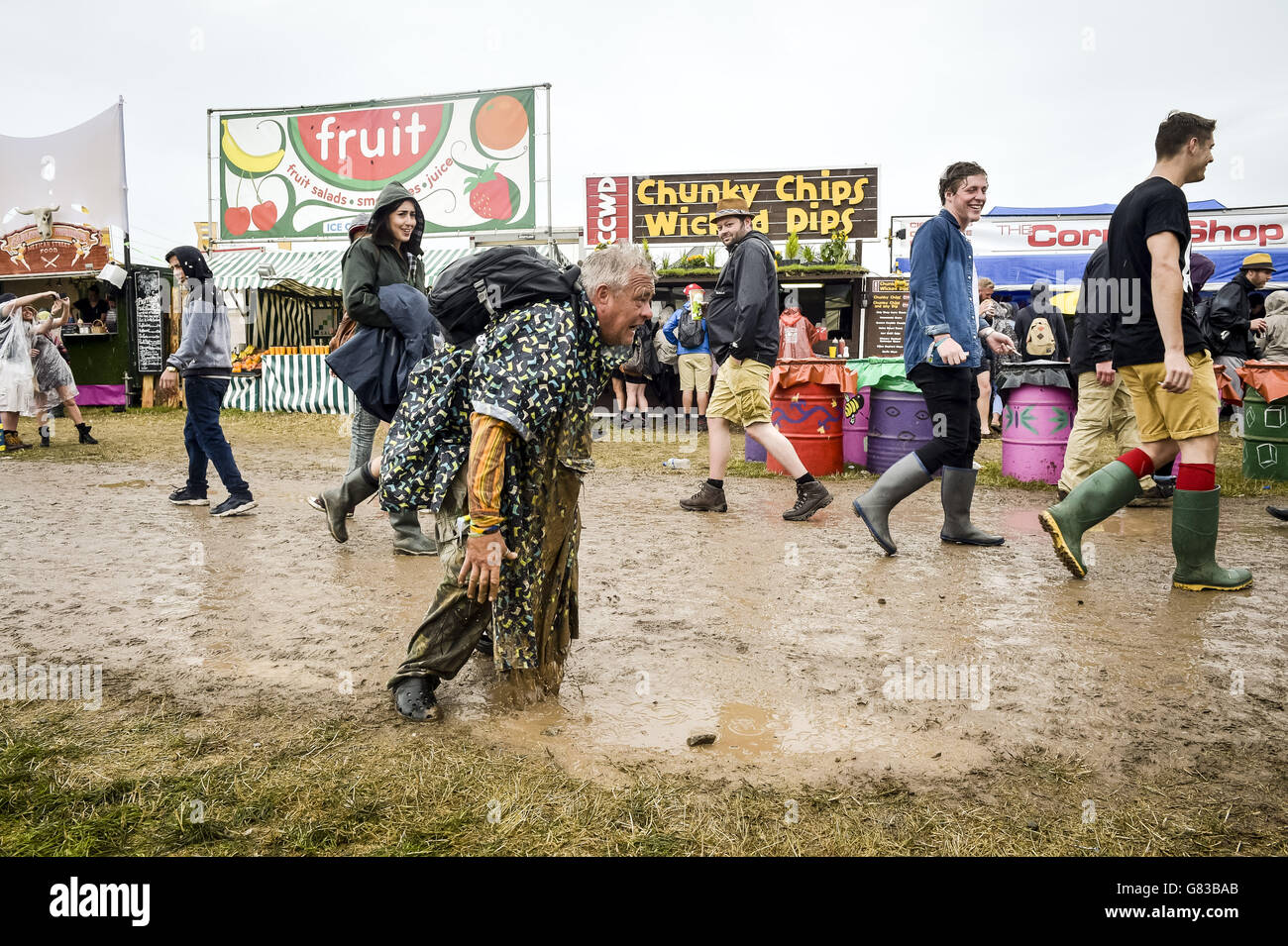 Un festival glisse dans la boue pendant une douche de pluie au Glastonbury Festival, à la ferme digne de Somerset. APPUYEZ SUR ASSOCIATION photo. Date de la photo: Vendredi 26 juin 2015. Le crédit photo devrait se lire : Ben Birchall/PA Wire Banque D'Images