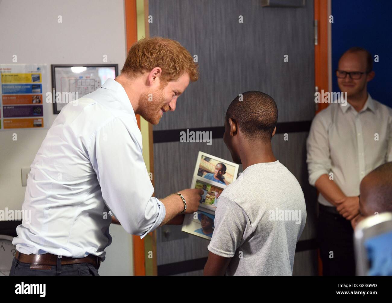 Le prince Harry (à gauche) est regarde les photos avec Relebohile 'Mutsu' Potsane après avoir vu les membres de la chorale de jeunes Basotho pendant leurs répétitions à la Brit School avant d'une performance à l'Sentebale Concert. Banque D'Images