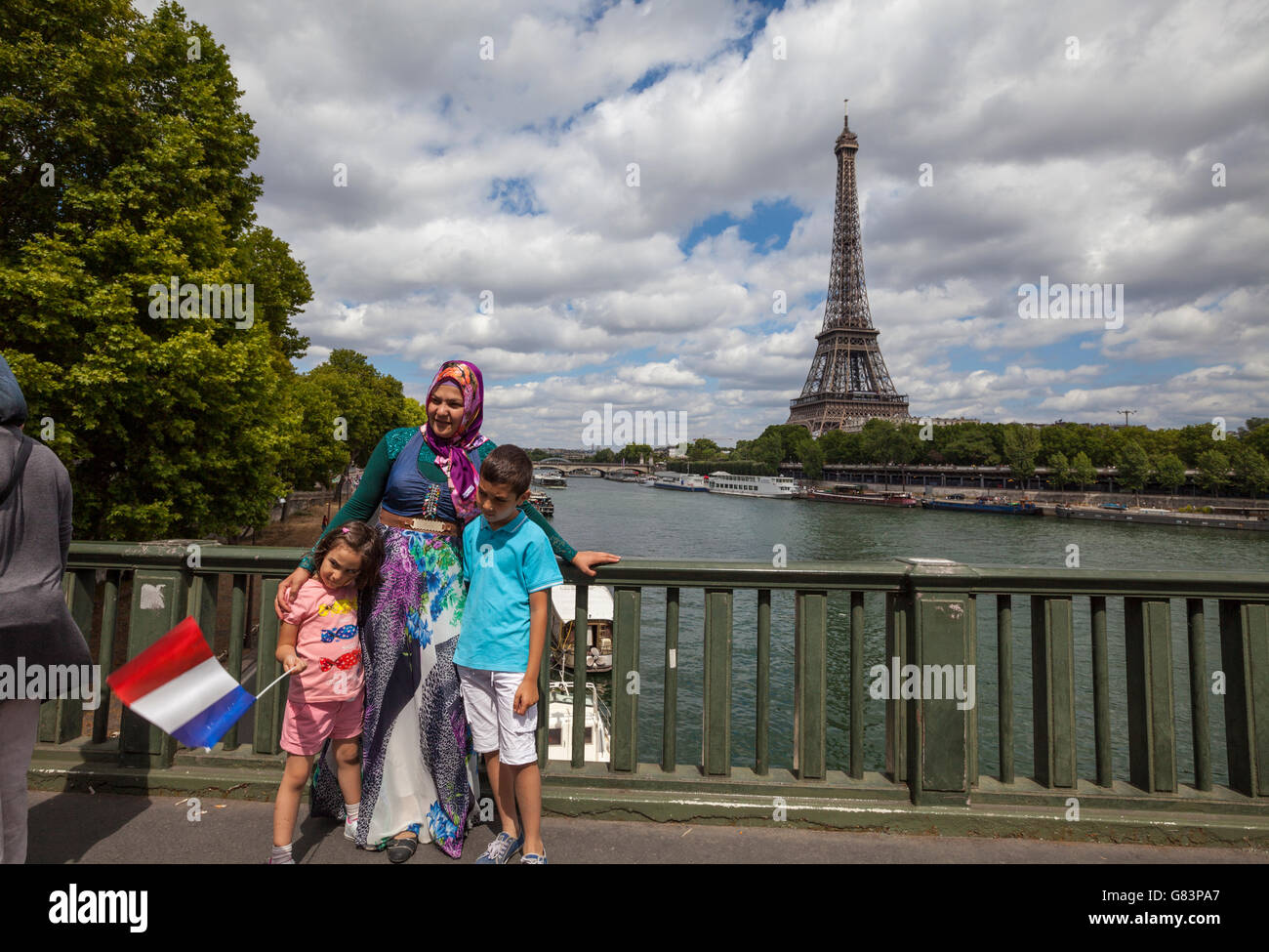 Femme musulmane posant avec un drapeau français à la Seine pont avec Tour Eiffel ( Tour Eiffel ) en arrière-plan, Paris, France Banque D'Images