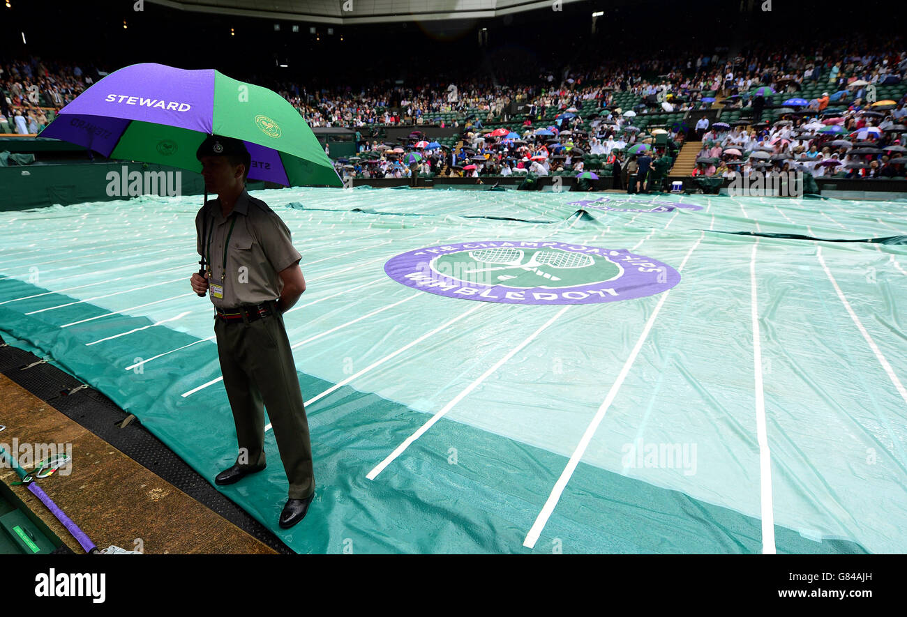 Les arrêts de pluie jouent sur le court central au cours de la neuf journée des championnats de Wimbledon au All England Lawn tennis and Croquet Club, Wimbledon. Banque D'Images