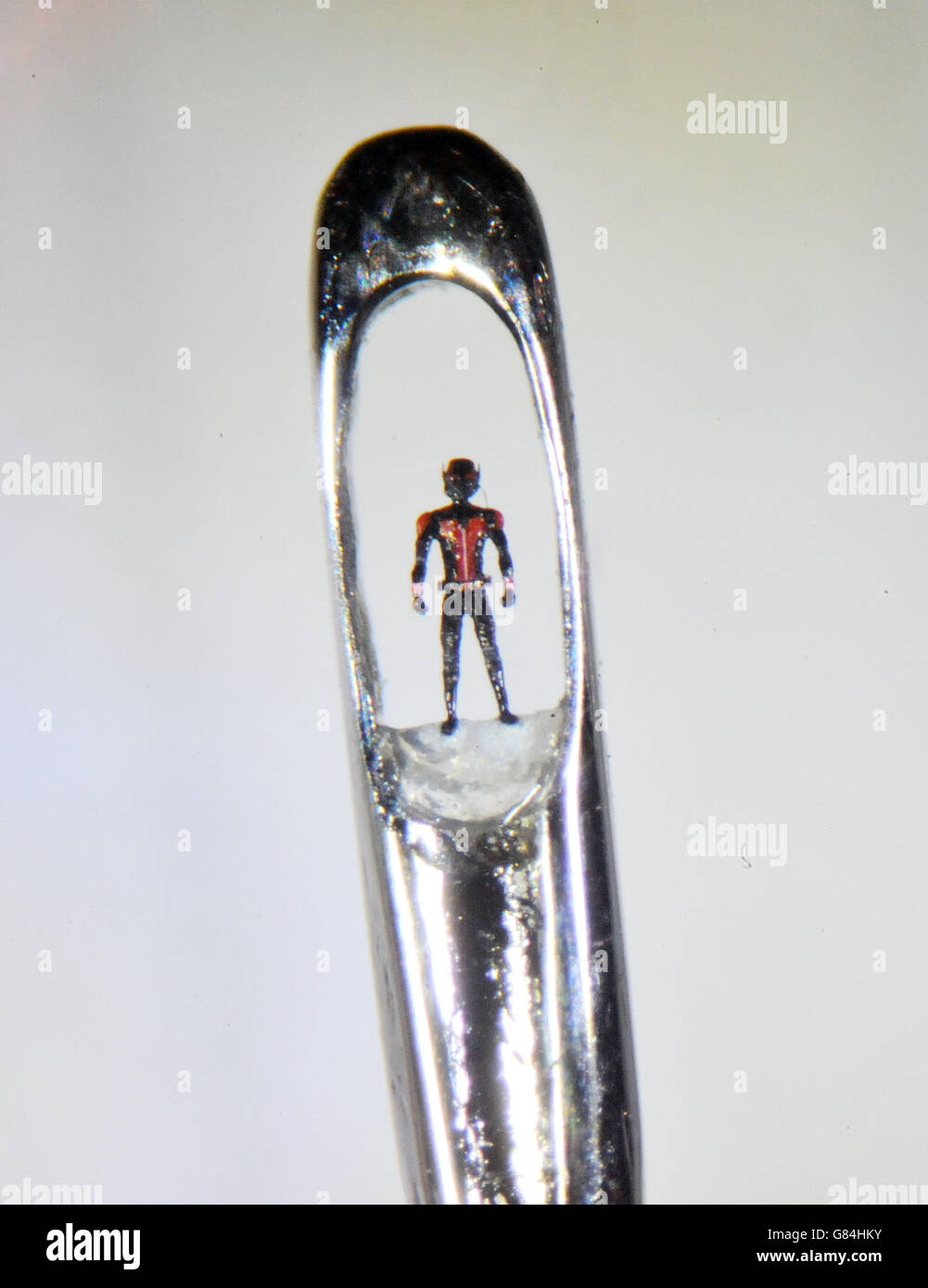 Une micro-sculpture de Ant-Man dans l'œil d'une aiguille par l'artiste britannique Willard Wigan, lors d'un appel photo pour une galerie d'art miniature mesurant 4,5m par 3,2m présentant des œuvres du nouveau film Ant-Man, à la gare de Old Street, Londres. Banque D'Images