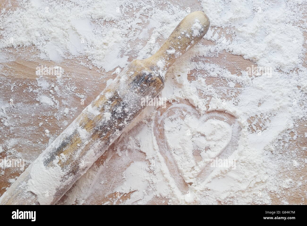 Coeur dessiné dans la farine avec rouleau à pâtisserie Banque D'Images