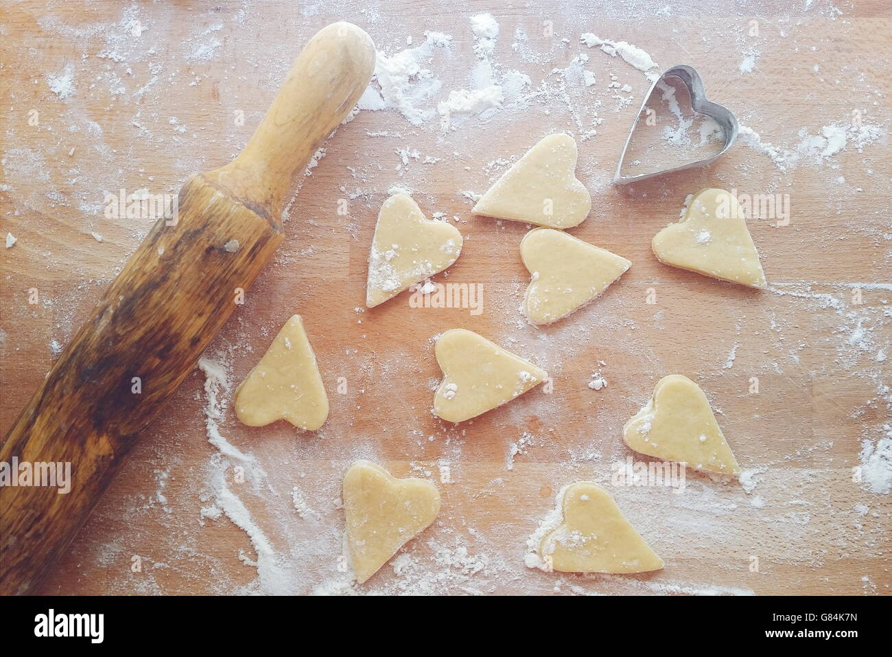 Des biscuits en forme de coeur avec rouleau à pâtisserie et emporte-pièce Banque D'Images