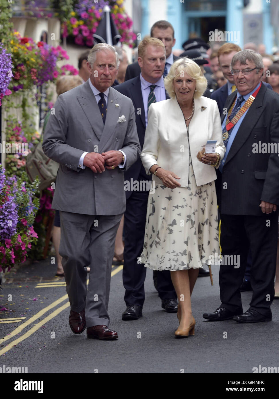 Le prince de Galles et la duchesse de Cornouailles avec des dignitaires locaux comme la promenade d'une rue à Padstow comme ils visitent la ville de Cornouailles. Banque D'Images
