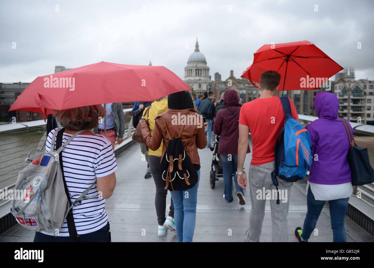 Les gens utilisent des parapluies lorsqu'ils traversent le Millennium Bridge de Londres, par temps humide, alors que le Royaume-Uni semble susceptible d'éviter une malédiction de précipitations prolongées préconnue dans la légende britannique, malgré un début brumeux pour une grande partie du pays, Comme le mythe de la Saint-Sin's Day l'indique si elle pleut le 15 juillet, le temps humide persistera pendant 40 jours et 40 nuits. Banque D'Images