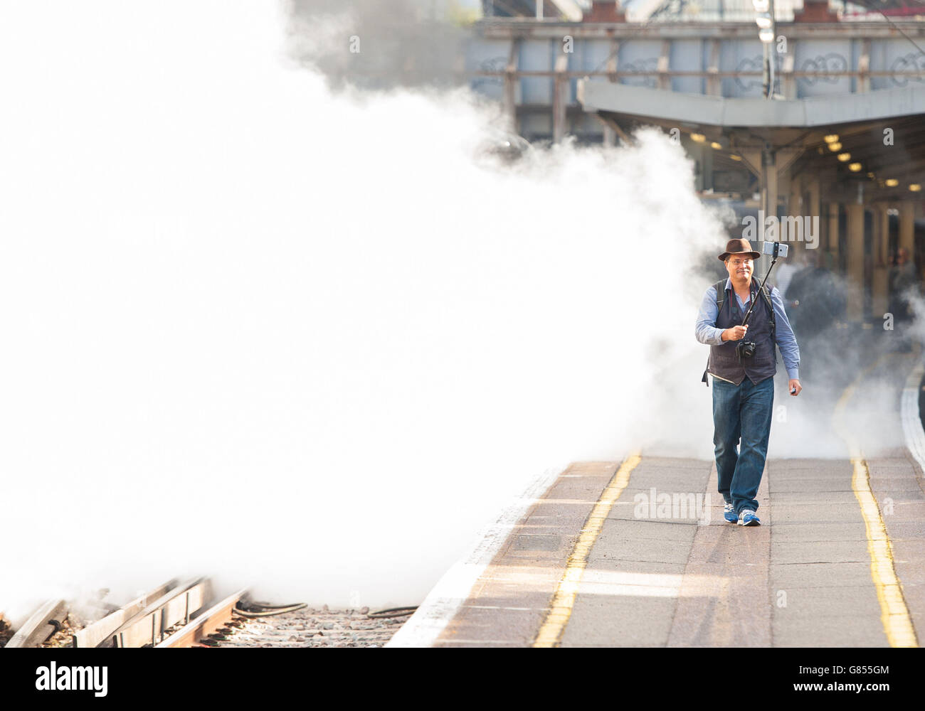 Le passionné de vapeur David Crosby, de Brisbane, en Australie, utilise un bâton de selfie pour prendre une photo avec 'Tangmere', une locomotive à vapeur 1947-6-2 de la classe de la bataille de Grande-Bretagne de 4, tirant le train Dorset Coast Express à Weymouth à la gare Victoria, Londres. Banque D'Images