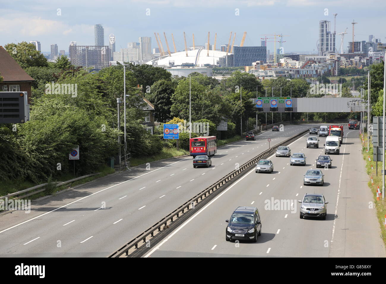 La voie à quatre voies A2 s'approche du tunnel Blackwall et des docks de Londres par le sud. Montre le Millennium Dome et les gratte-ciel de Londres au-delà. Banque D'Images