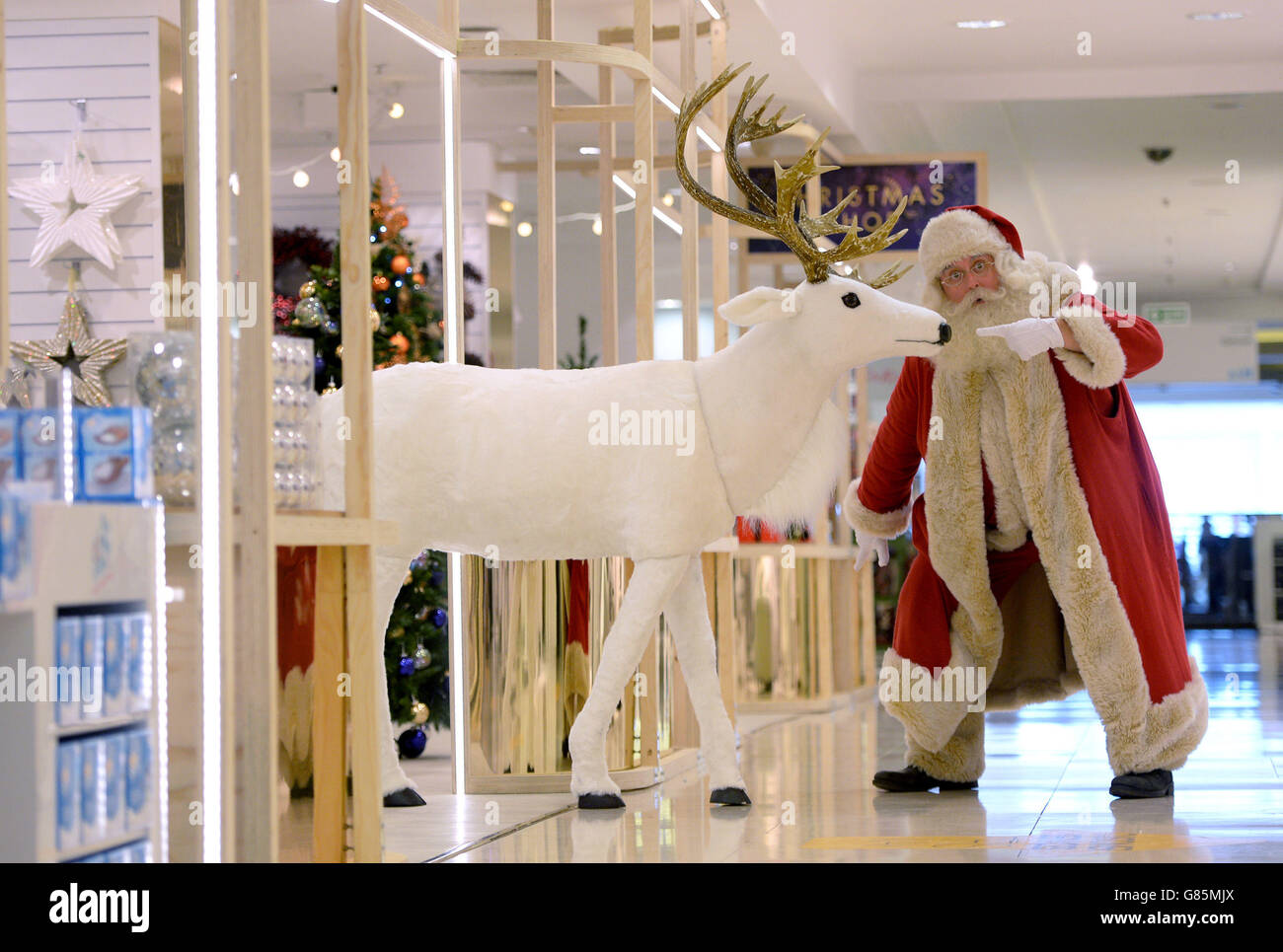 Un homme habillé comme Père Noël à côté d'un renne comme Selfridges ouvre leur boutique de Noël dans le magasin phare d'Oxford Street, Londres. Banque D'Images