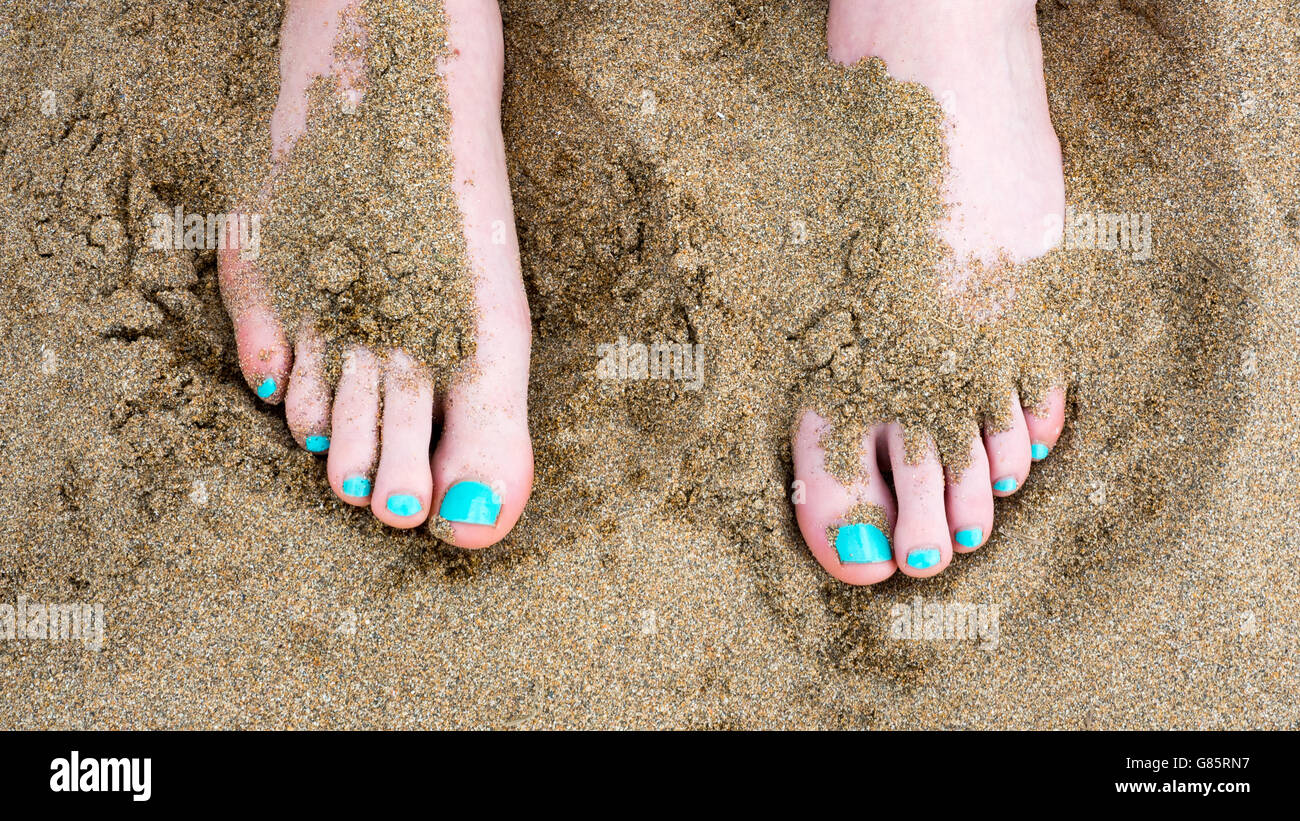 Les orteils contre le sable à la plage Banque D'Images