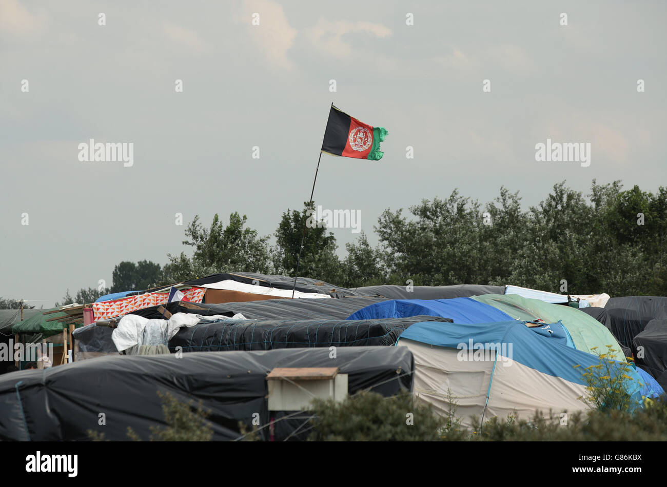 Le drapeau de l'Afghanistan survole des tentes à l'intérieur du camp de migration connu sous le nom de nouvelle Jungle à Calais, en France. Banque D'Images