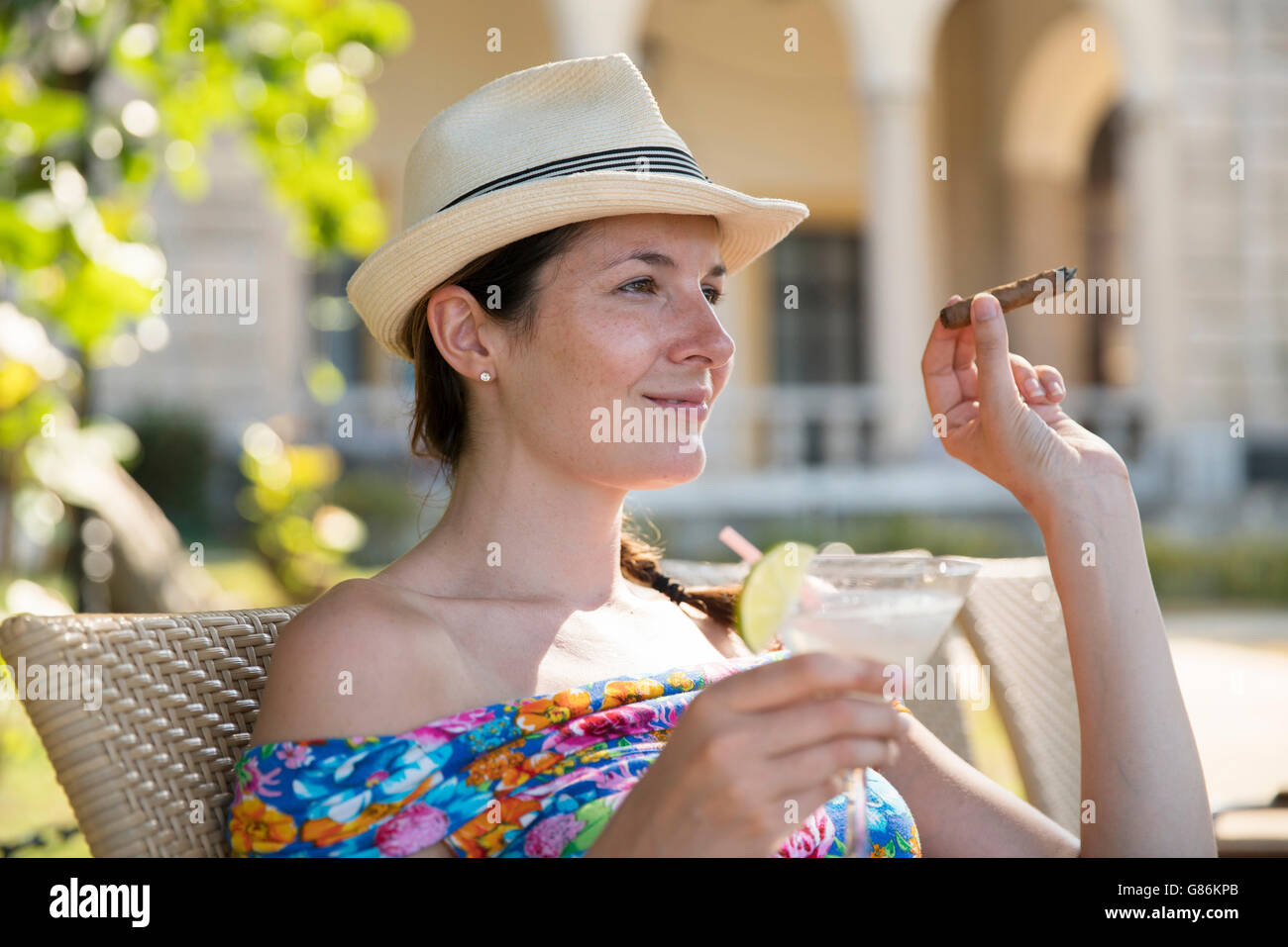 Une femme dégustant un cocktail et un cigare dans un hôtel à La Havane, Cuba Banque D'Images
