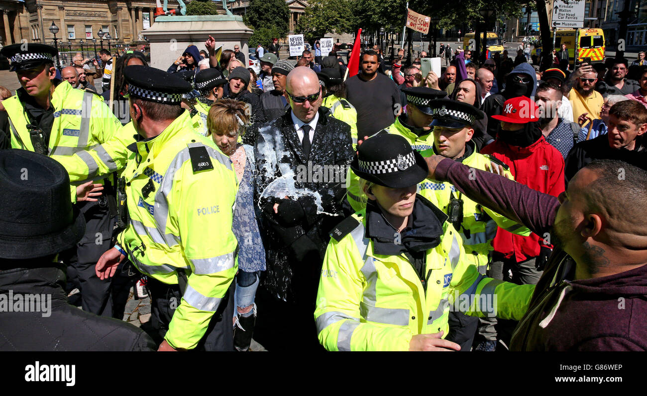 Un liquide est lancé contre un homme et une femme alors que la police interviendrait à Liverpool pour protéger les membres de l'action nationale alors qu'elle annulait sa « Marche pour l'homme blanc » à la suite de deux contre-protestations antérieures du réseau antifasciste et de Unite contre le fascisme. Banque D'Images