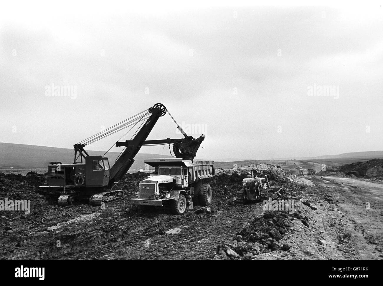 Une tourbière est déblayée par un grand creuseur mécanique à Pole Moor, pendant la construction du M62. Banque D'Images