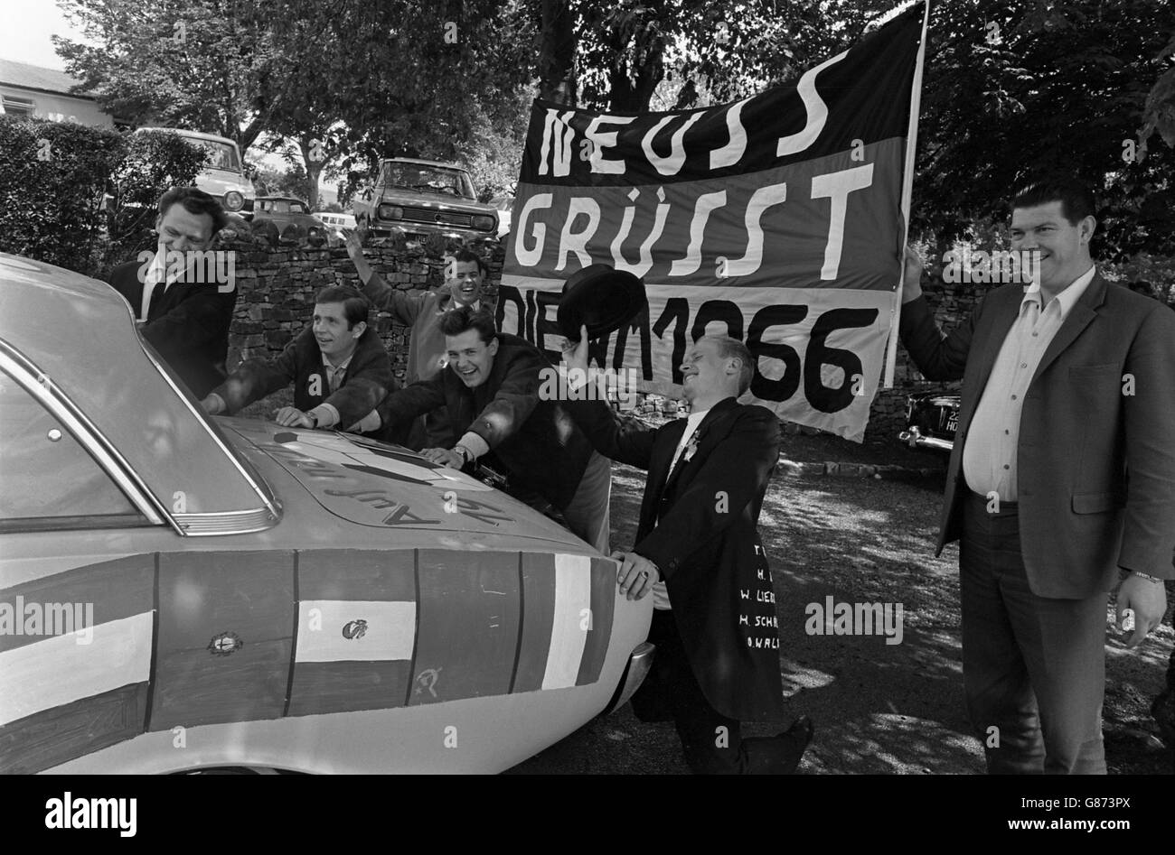 Football - coupe du monde de la FIFA Angleterre 66 - finale - Angleterre / Allemagne de l'Ouest - Stade Wembley.Les fans de Neuss en Allemagne de l'Ouest poussent une voiture, décorée avec les drapeaux des pays concurrents. Banque D'Images