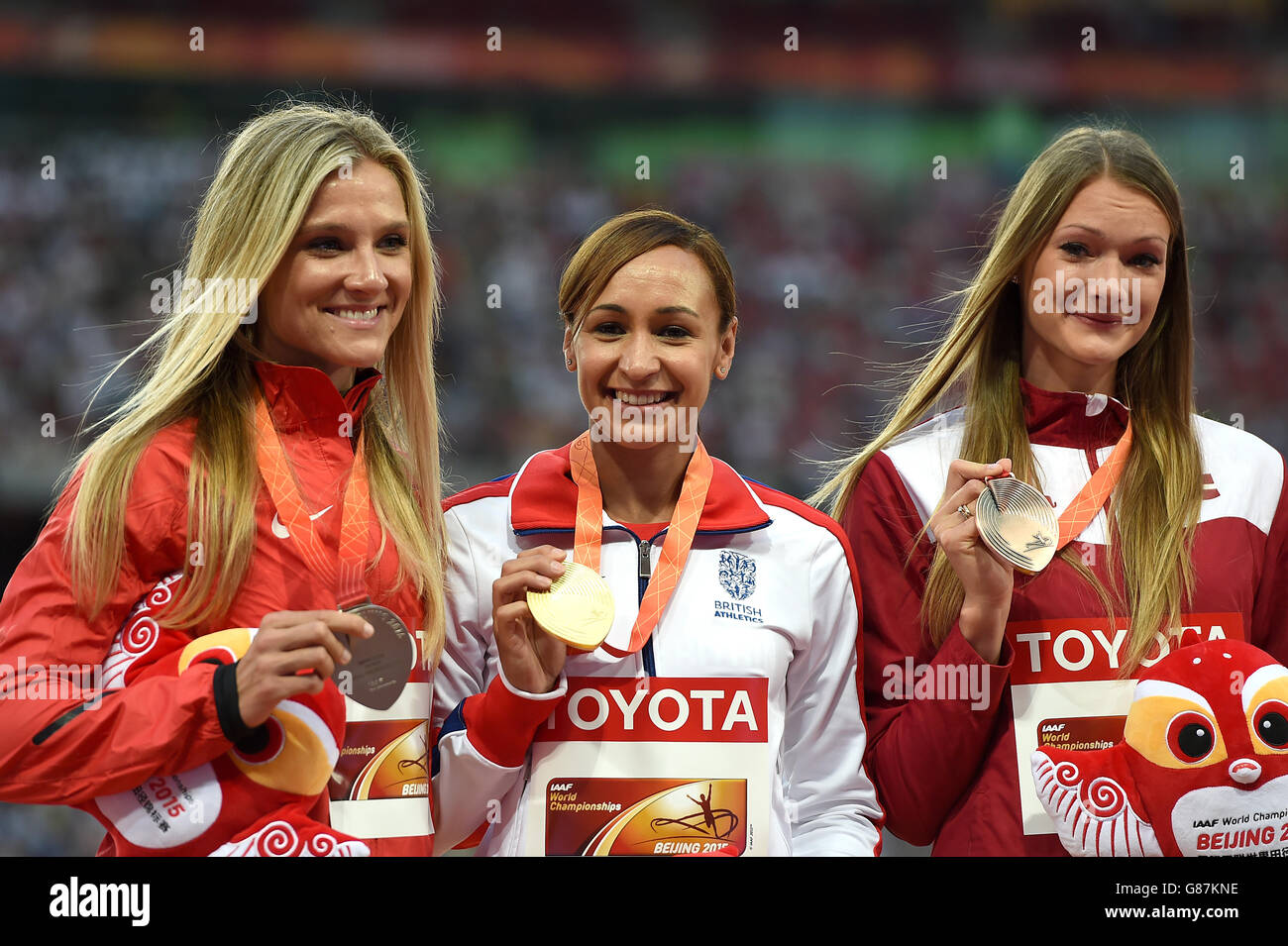 Jessica Ennis-Hill, en Grande-Bretagne, célèbre avec sa médaille d'or sur le podium lors de la cérémonie de présentation du Women's Heptathlon, aux côtés de la médaillée d'argent Brianne Theisen-Eaton du Canada (à gauche) et de la médaillée de bronze Laura Ikauniece-Admidina (à droite) de Lettonie, le troisième jour des Championnats du monde de l'IAAF au Stade national de Beijing, en Chine. Banque D'Images