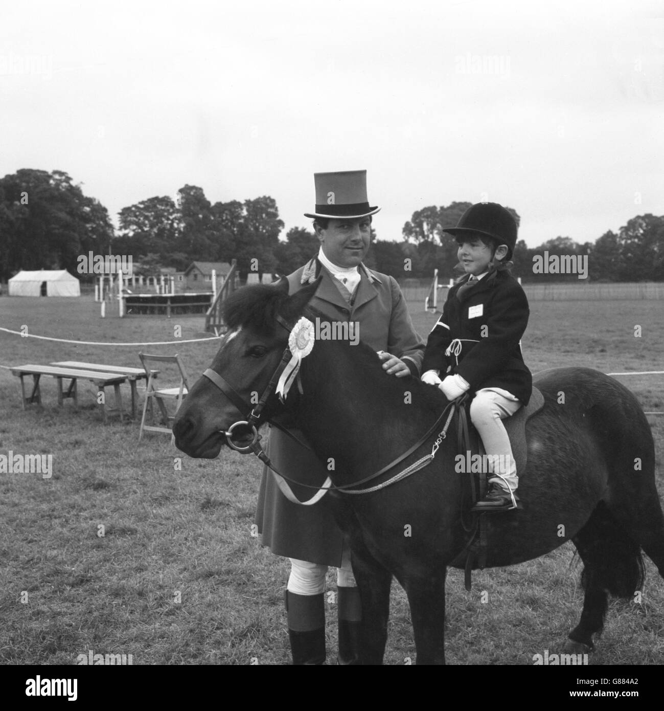 Ron Hill, de Slough, qui a été la garde de bague à la plupart des spectacles de chevaux importants, avec sa fille Jane, qui roule son propre Bambi dans la classe pour les enfants poney dirigeant la rein au Royal Windsor Horse Show. Banque D'Images