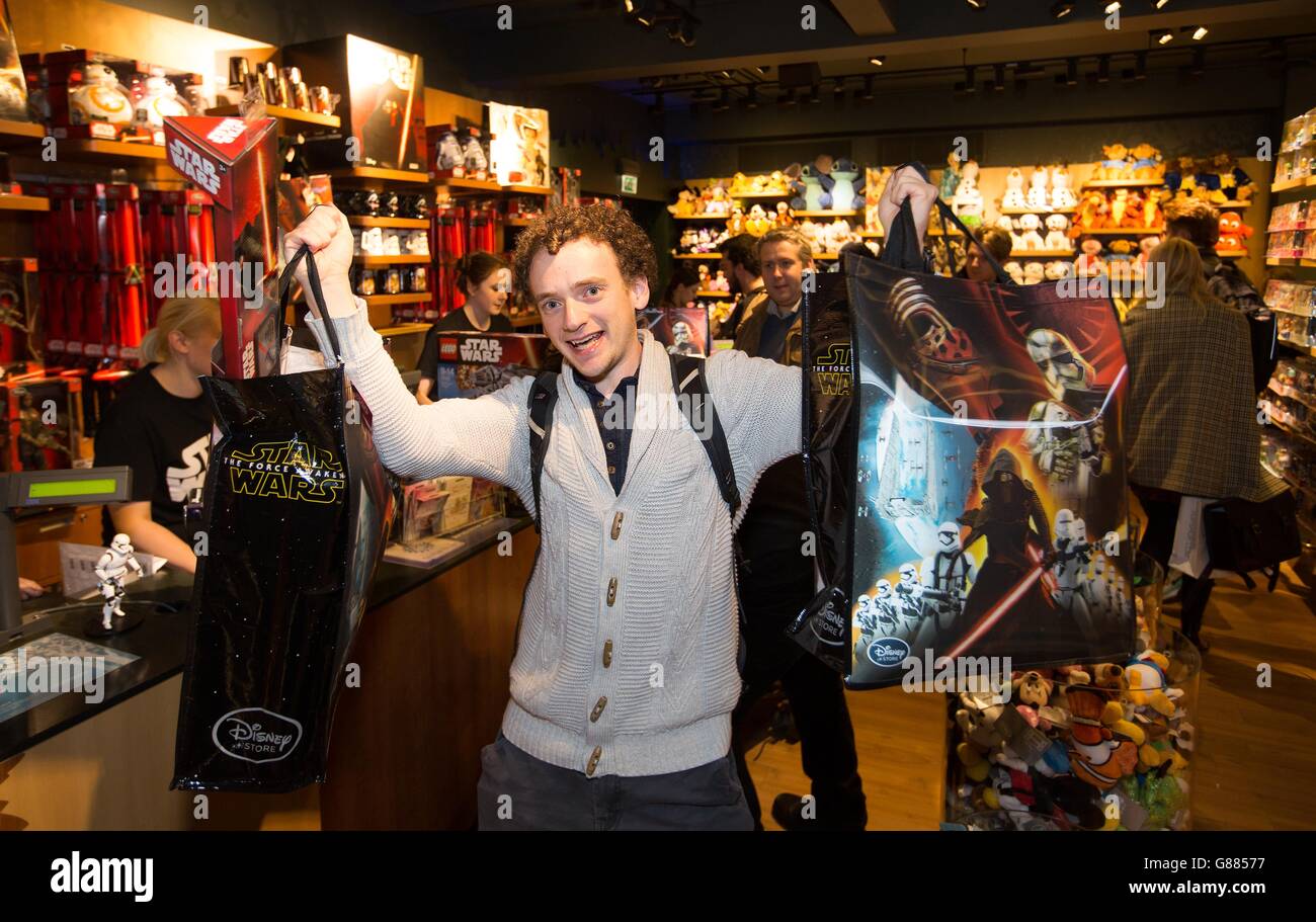 Thomas Blakey, 26 ans, de Londres, est le premier client à acheter un article de la gamme de souvenirs Star Wars: The Force Awakens, lors du lancement à minuit, au Disney Store sur Oxford Street à Londres. Banque D'Images