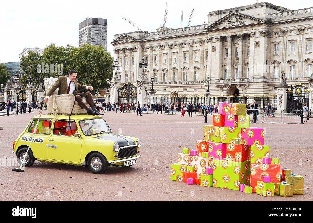 M. Bean, joué par Rowan Atkinson, célèbre le 25e anniversaire du personnage sur le Mall en face de Buckingham Palace, Londres, sur sa marque Mini. Banque D'Images