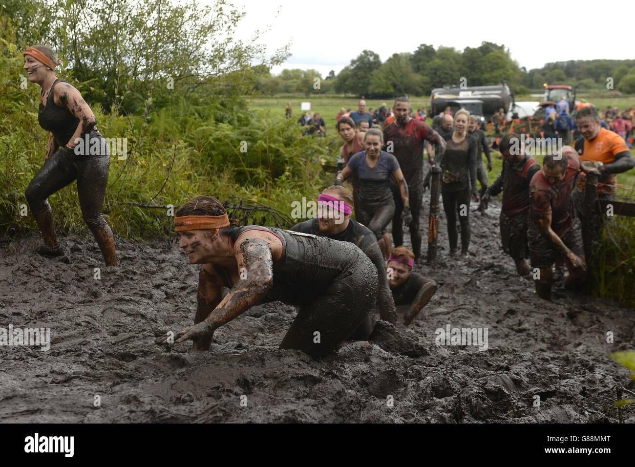 Les participants parcourent la boue épaisse pendant le Tough Mudder North West au domaine de Cholmondeley à Malpas, Cheshire. Banque D'Images