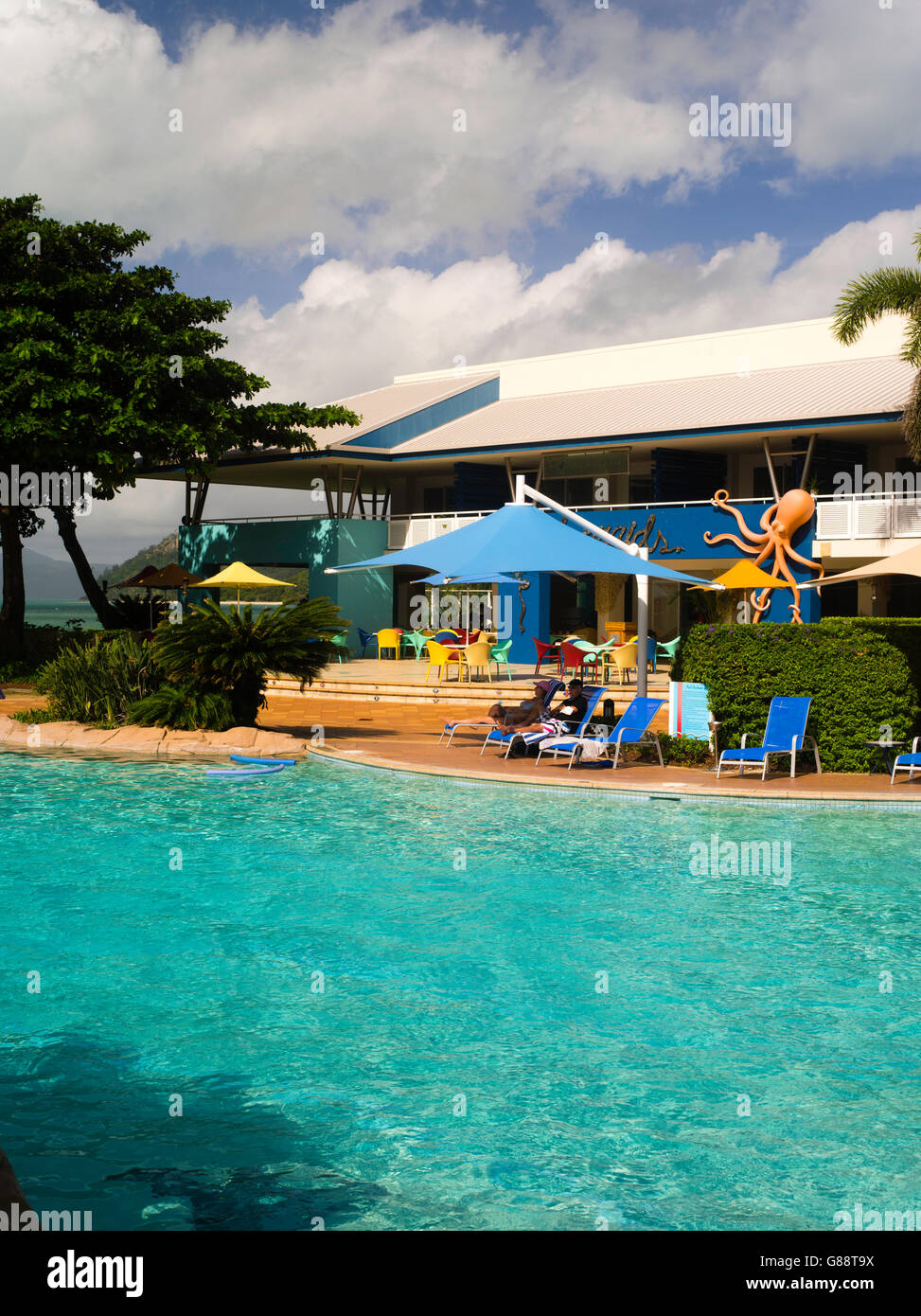 Détente au bord de la piscine à Daydream Island resort ; Whitsunday Islands, Queensland, Australie. Banque D'Images