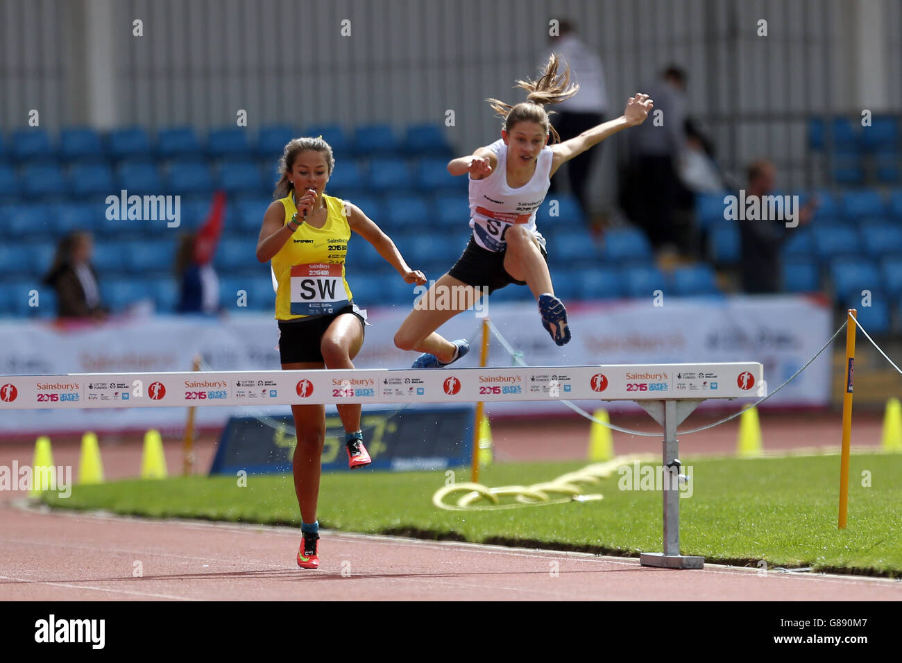 Le Yasmin Austridge du Sud-est de l'Angleterre saute un obstacle pendant les filles de 1500m steeplechase aux Jeux scolaires de Sainsbury 2015 à l'arène régionale de Manchester. Banque D'Images