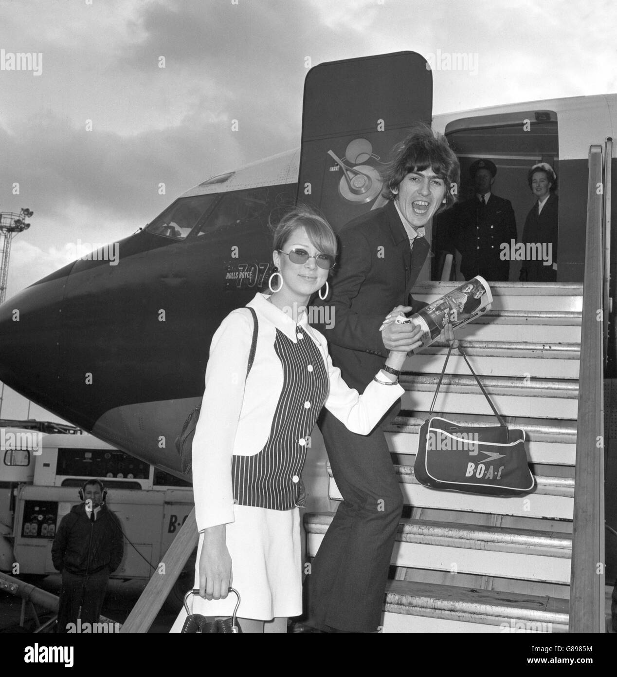 George Harrison des Beatles et sa nouvelle femme Patti embarquèrent à bord d'un avion à l'aéroport de Londres, où ils volaient à la Barbade pour leur lune de miel. Banque D'Images