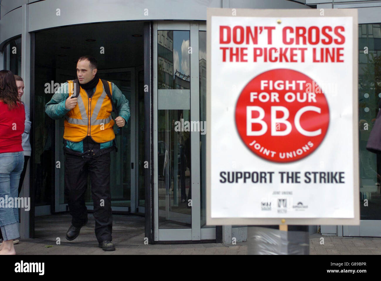 Un picketeur de la BBC regarde un homme qui quitte le centre de télévision de la BBC alors que des dizaines d'employés de la BBC protestent contre 4,000 propositions de réduction d'emplois au sein de la société. Banque D'Images