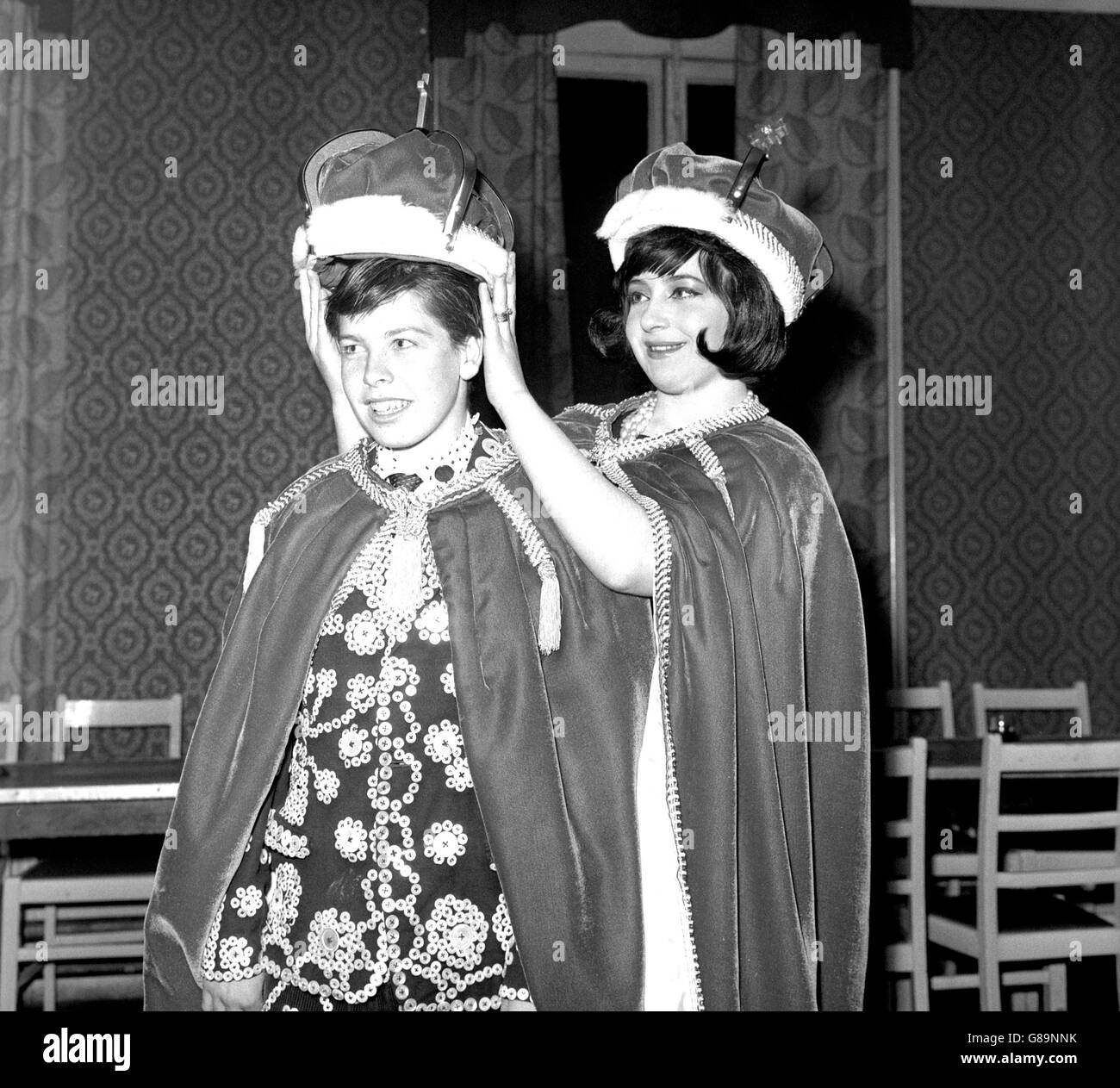 George Nutley, à 15 ans, le plus jeune roi de Hoxton, à l'est de Londres, essaie sa couronne pour la taille, avec l'aide de sa sœur Carol, 18 ans.Il a été couronné ce soir à la tête de la Reine, rue Hoxton.Carol agira comme sa reine de la petite enfance jusqu'à ce qu'il se Marie. Banque D'Images