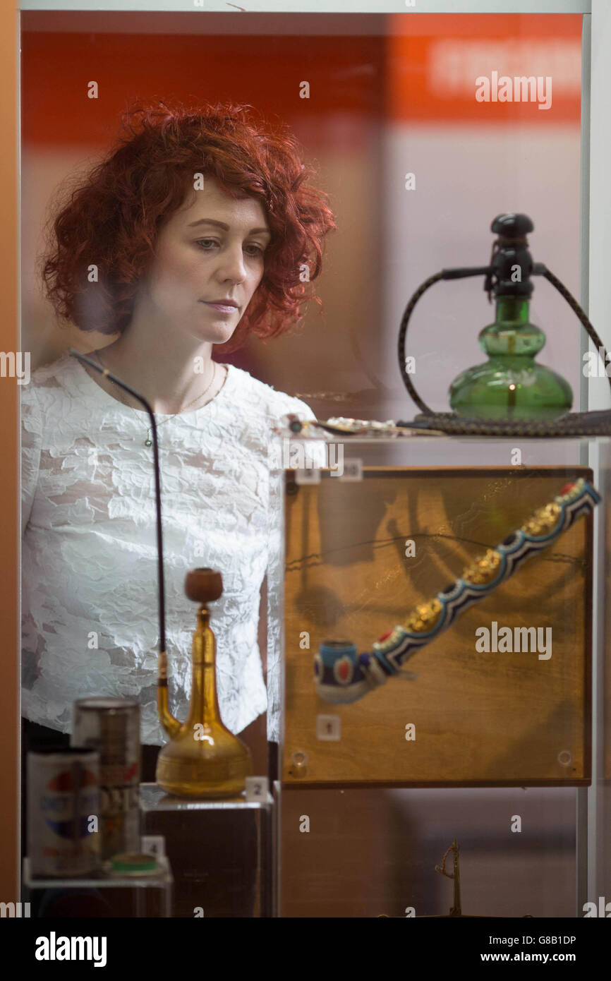 L'employé du musée Sian-Estelle Petty regarde la drogue paraphhernalia, qui est exposée dans le cadre de l'exposition découverte du crime Museum au Musée de Londres, qui s'ouvre au public vendredi. Banque D'Images