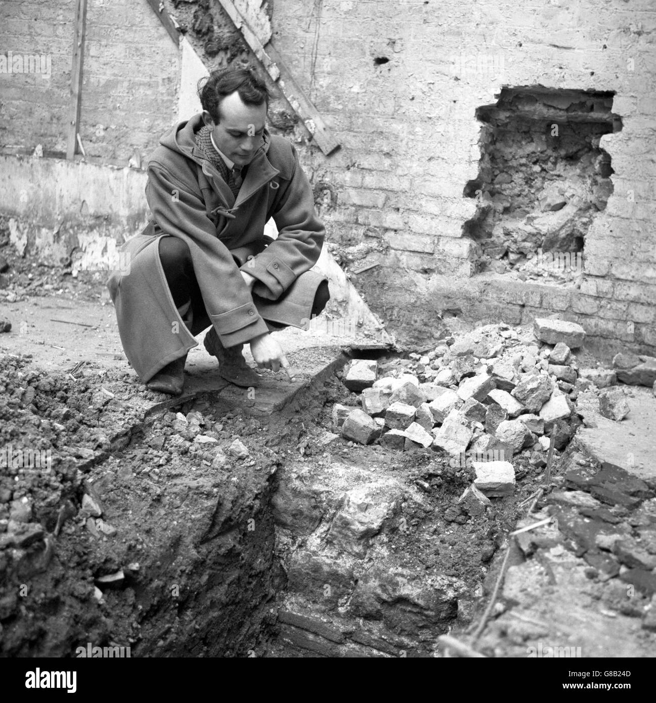 Peter Marsden, assistant d'excavation au Musée Guildhall, soulignant une partie d'un mur romain datant d'environ 200 après J.-C., qui a été découvert lors de fouilles sur le site d'un ancien entrepôt à l'arrière de l'ancien Bailey. Banque D'Images