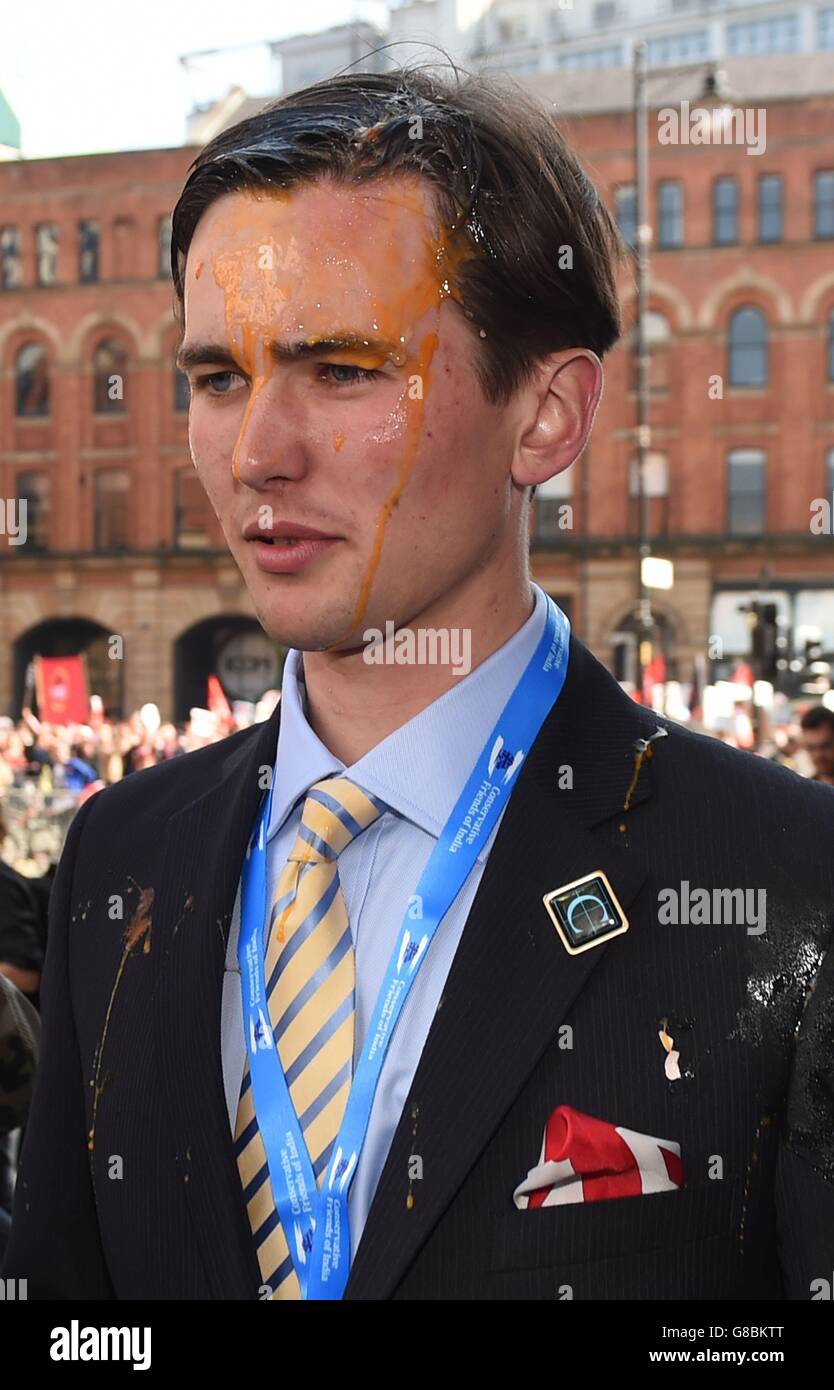 Un jeune délégué conservateur après avoir été éveigé par des militants lors d'une marche anti-austérité avant le début de la Conférence du Parti conservateur à Manchester. Banque D'Images
