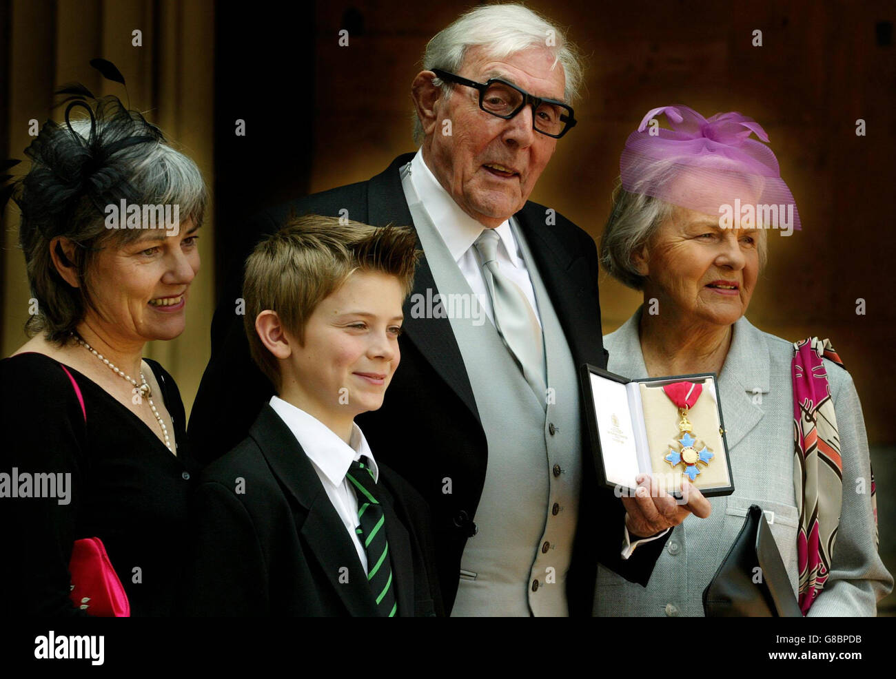 Eric Sykes, comédien vétéran, est accompagné de sa fille Kathy, de son petit-fils Thomas et de sa femme Edith après avoir reçu son CBE de la Reine. Banque D'Images