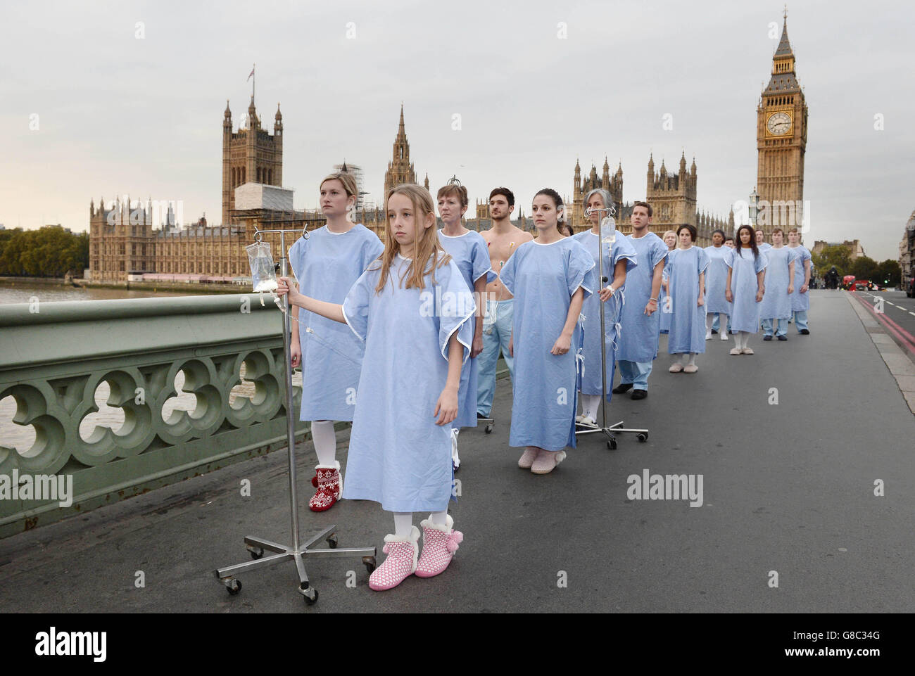 21 personnes vêtues de blouses chirurgicales et poussant des gouttes salines marchent parmi les navetteurs sur le pont de Westminster, Londres, pour souligner le nombre de patients britanniques qui meurent chaque semaine à la recherche d'une greffe d'organe, avant une nouvelle série documentaire Channel 5 appelée le Don de la vie. Banque D'Images