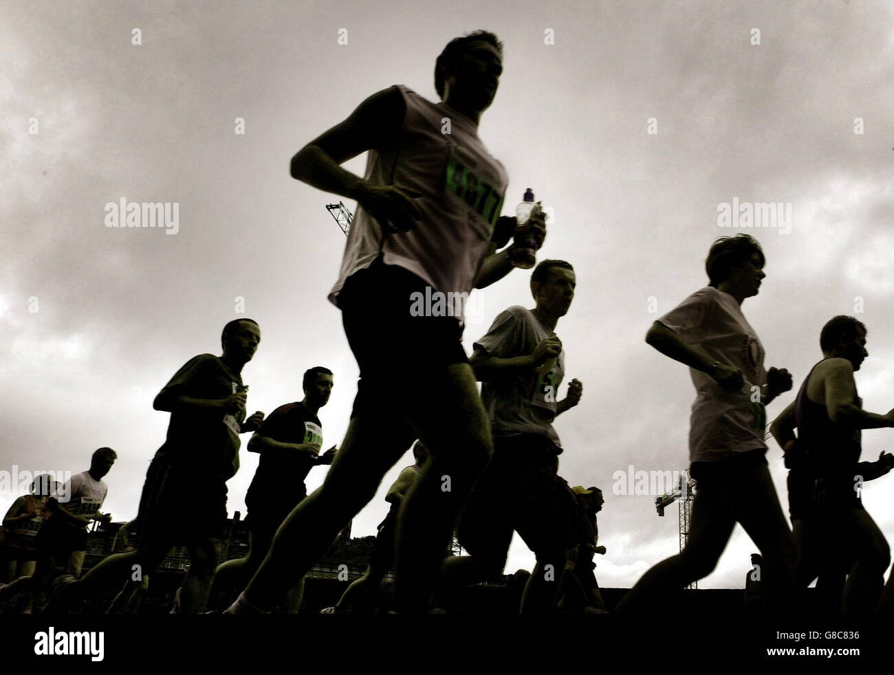 Les coureurs du marathon d'Édimbourg de 2005 se sont mis en route par temps humide. La course pittoresque commencera à 9:00 depuis Holyrood Park, en suivant un itinéraire qui mène au Holyroodhouse Palace, à Princes Street et au Parlement écossais. Banque D'Images
