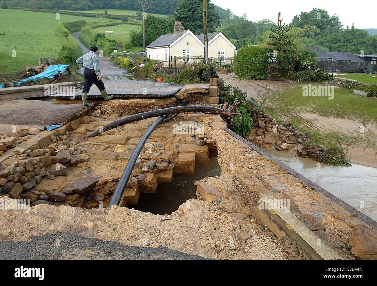 Les résidents de Hawnby, dans le North Yorkshire, regardent le pont vers leur village après qu'il a été lavé par des inondations soudaines de nuit. Neuf personnes ont été signalées comme disparues après un déluge à Helmsley, mais elles ont été trouvées plus tard en sécurité et bien. Banque D'Images