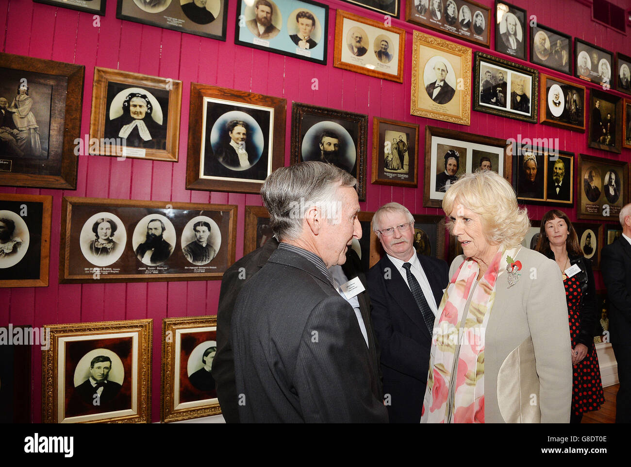 La duchesse de Cornwall parle aux descendants des premiers colons, dont les photos ornent les murs du Settlers Museum, dans la ville de Dunedin, sur l'île sud de la Nouvelle-Zélande. Banque D'Images